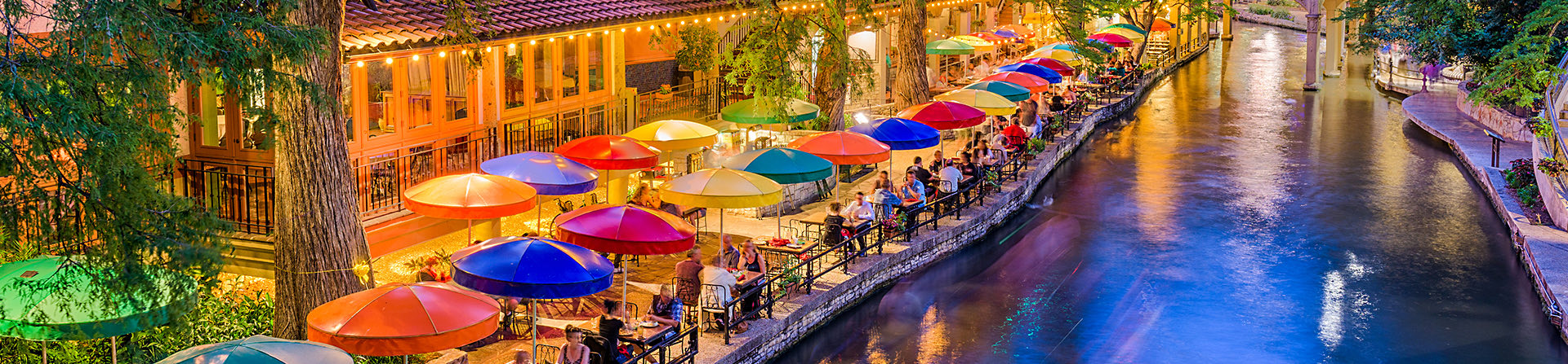 overhead view of the San Antonio riverwalk in the evening with the view of colorful umbrellas