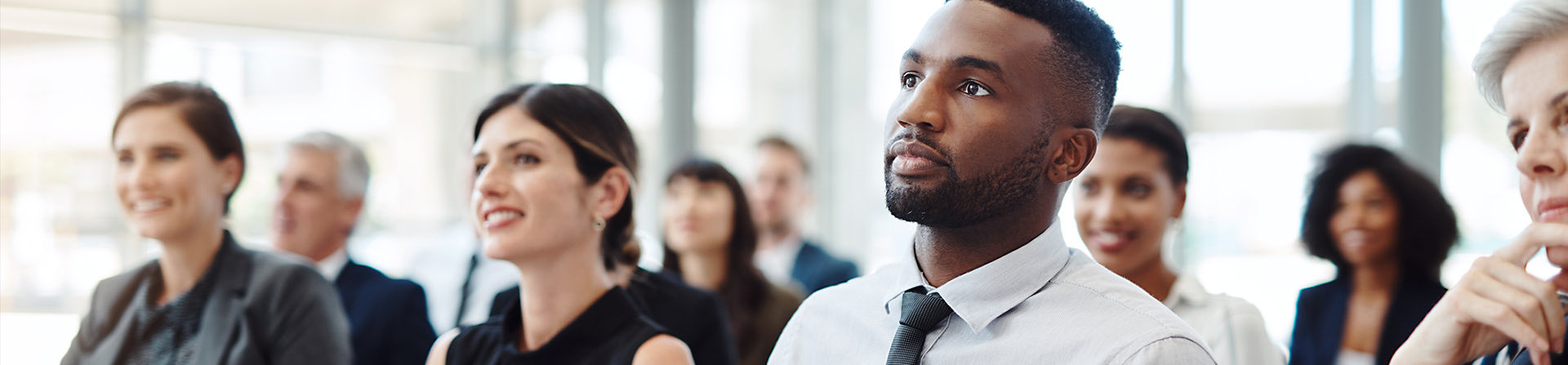 man looking at front of room attentively