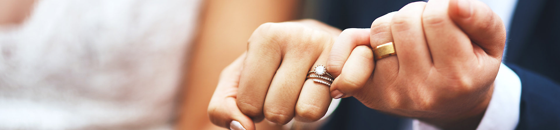 bride and groom holding their hands out to show rings