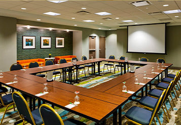 hotel room event space with tables arranged to face one another