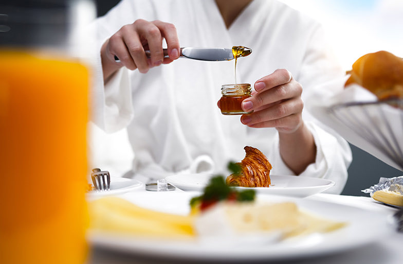 person serving a dollop of honey in robe
