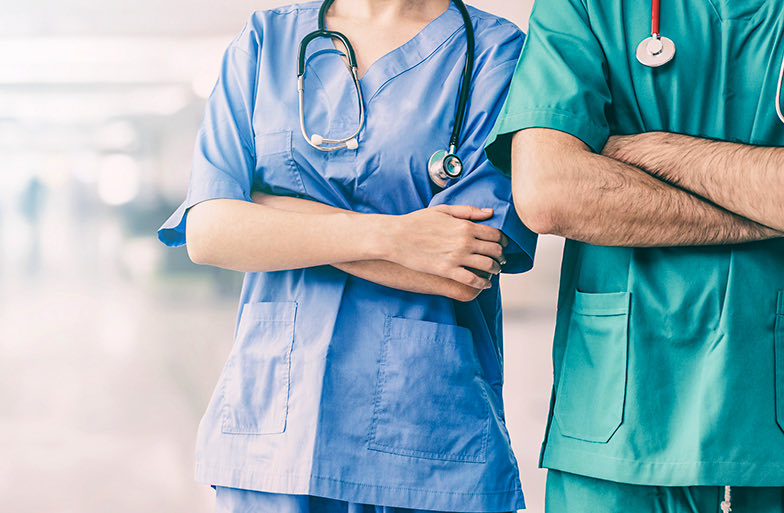 headless shot of people in scrubs with arms crossed
