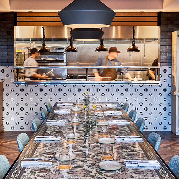 hotel83 web raleigh dining 01 2 spaces kitchen 5fac67f8acccclong rectangular table in front of the chef's window