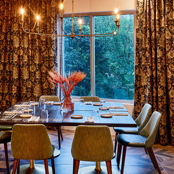 large dining table in front of a large window and large curtains