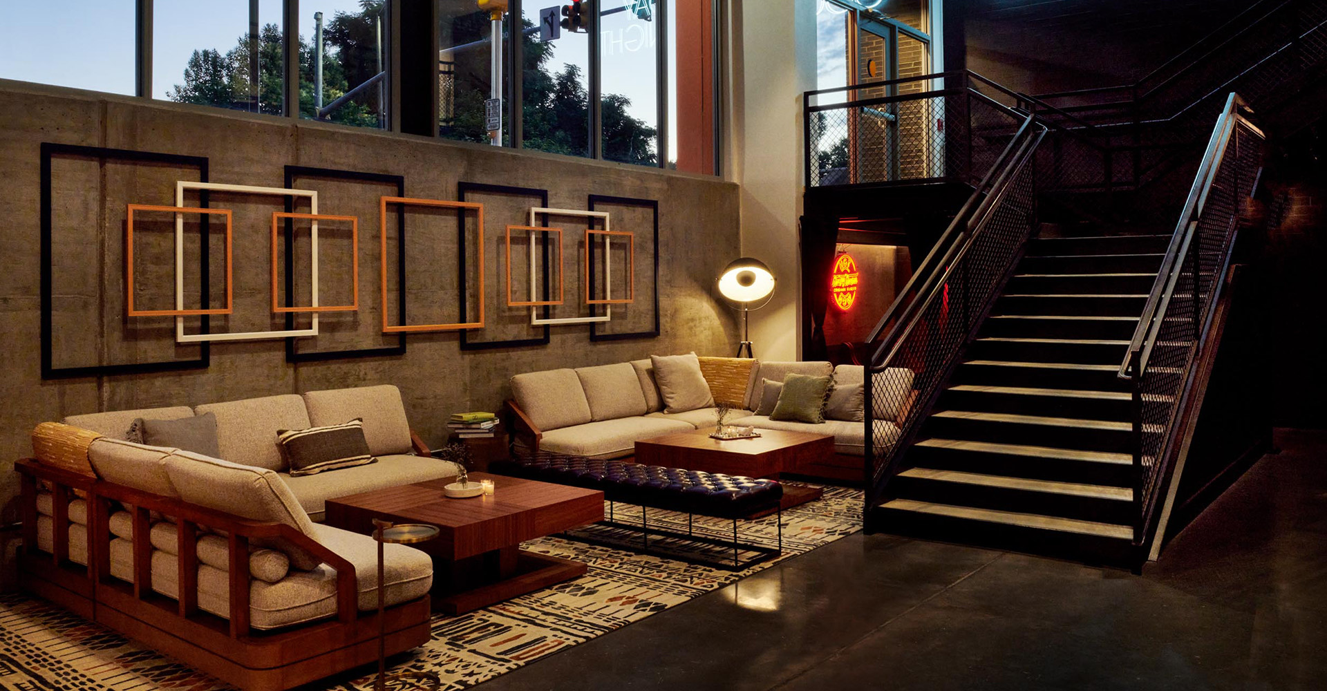 large comfy and dimly lit sectional couch at the bottom of a staircase