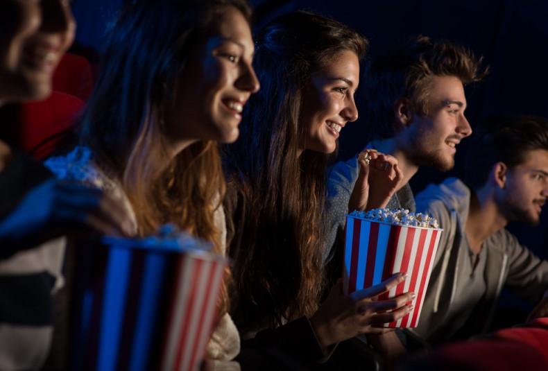 friends watching movie eating popcorn