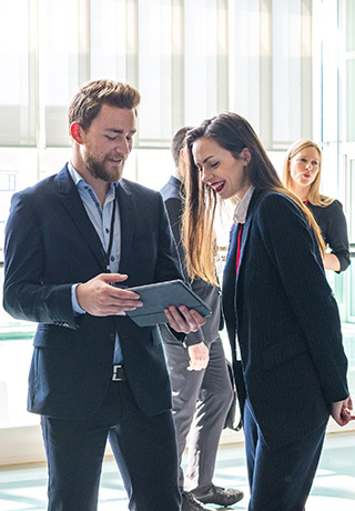 two business people looking at a tablet together at a conference