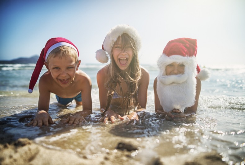 kids at the beach dressed as santa
