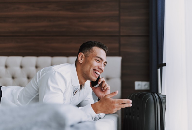 man talking on cell phone in hotel room
