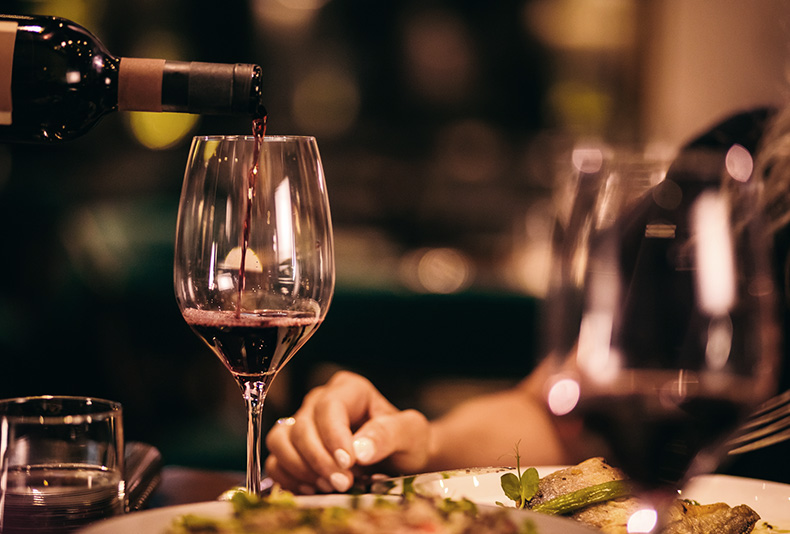 a candle lit dinner with red wine glasses