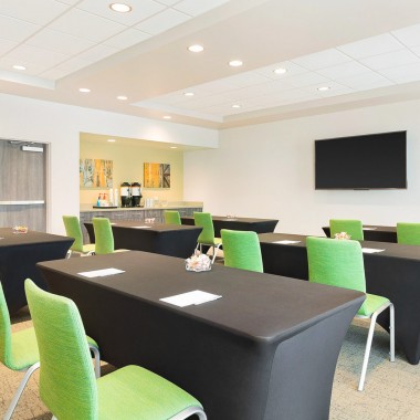 a meeting room with black tables and green chairs
