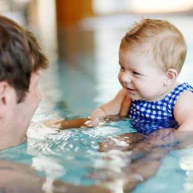 a man and a baby swimming in the pool