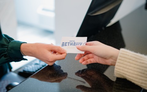 view of receptionist handing a guest a room key card
