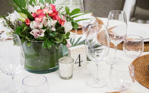 closeup view of a table setup for an special occasion with a boutique of roses in the center of the table