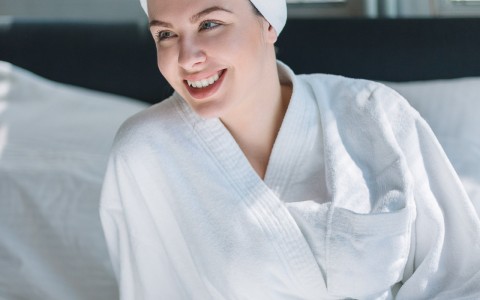 person in white robe and towel around her head