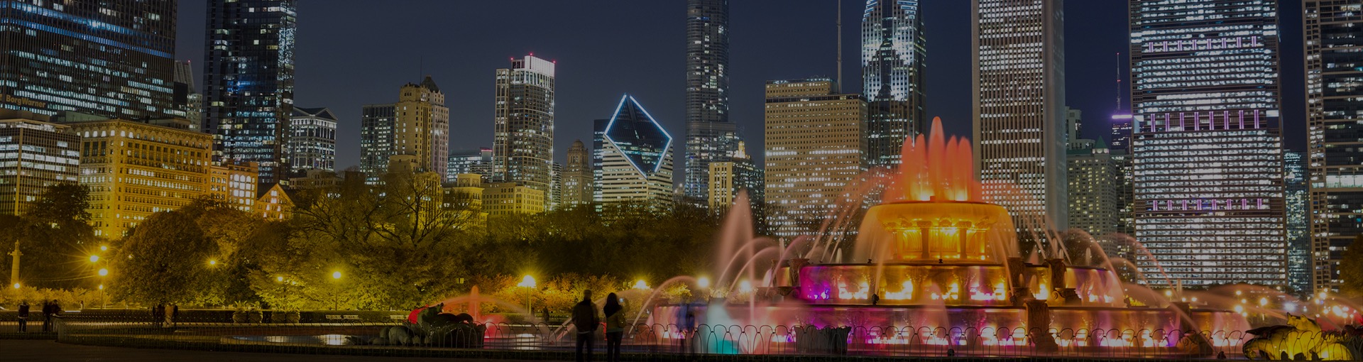 Lit up fountain next to city