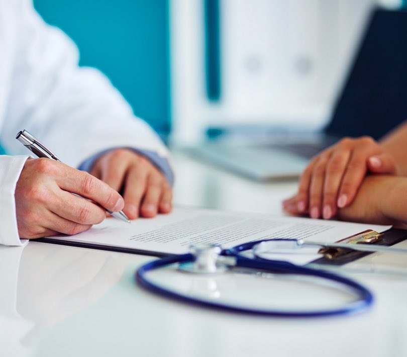Doctor filling out papers for patient