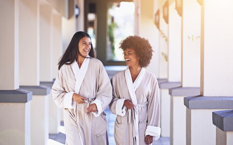two ladies in robe walking inside the property smiling and looking to different directions