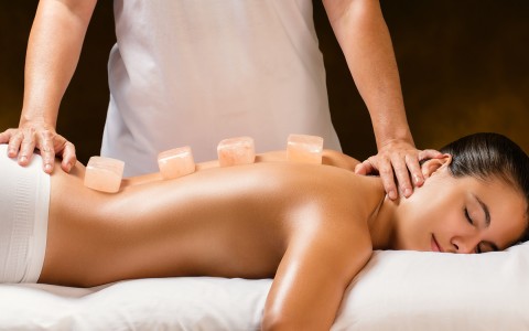 pleased woman laying down having a body massage 