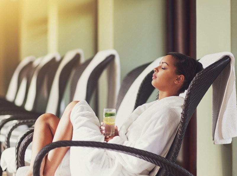 woman in robe having some rest while she s holding a drink