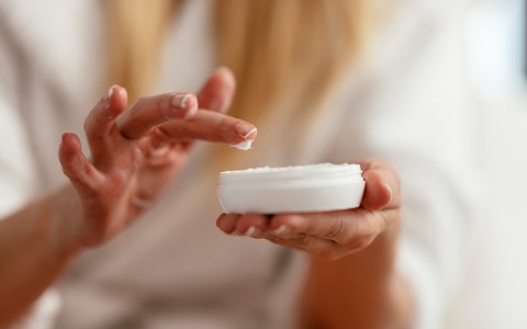 close up view of a female hands touching a body cream