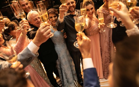 People smiling, cheering and making a toast celebrating the wedding