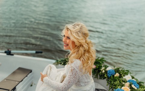 Bride in a boat smiling looking up
