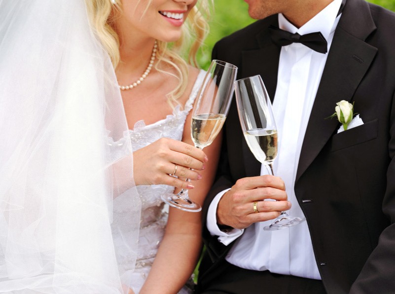 Closeup view of a bride and groom making a toast with champagne