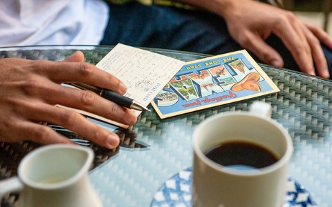 a cup of coffee with a texas postcard on a table