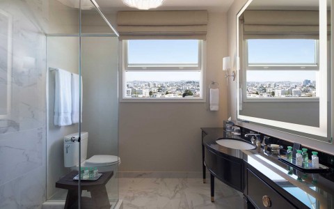 Bathroom with walk in shower, vanity, and view 
