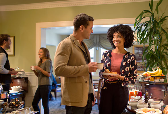 couple smiling and enjoying coffee during breakfast buffet