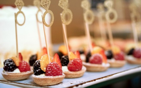 Many small fruit desserts served on a platter.
