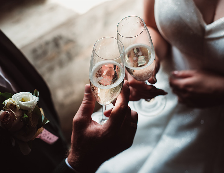 close up of a bride and groom toasting champagne in flutes