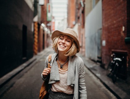 a woman with blonde hair in a hat smiling