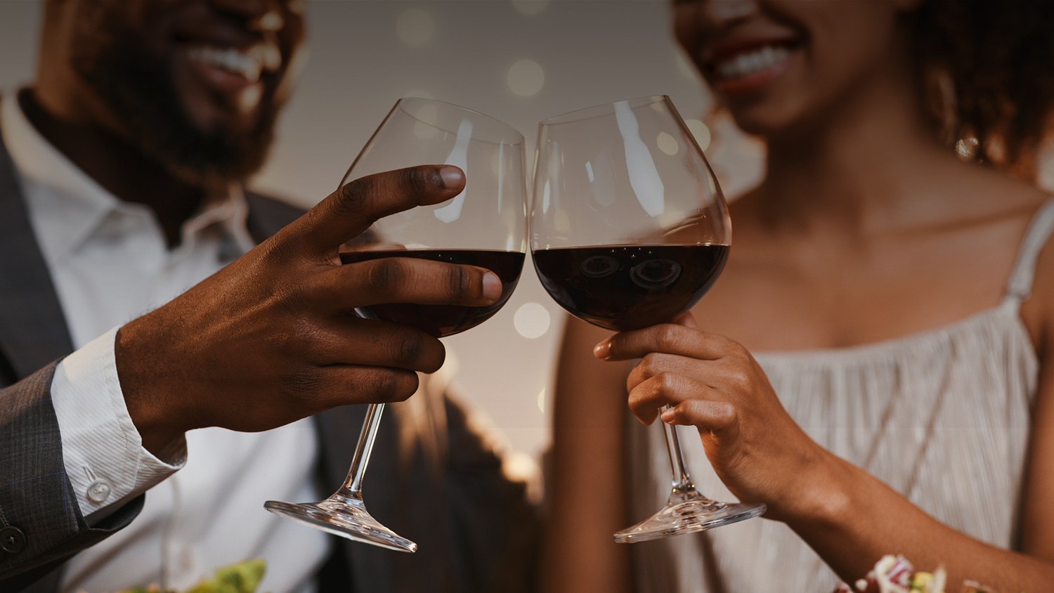 a couple toasting two glasses of wine