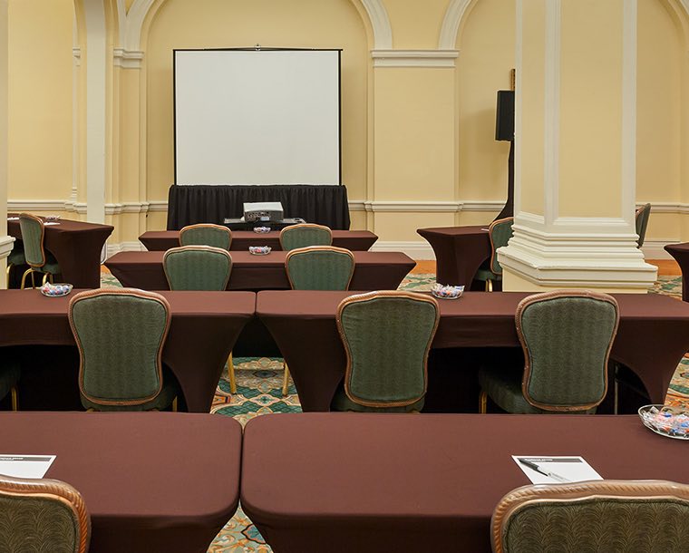 Rows of tables and chairs facing a projector