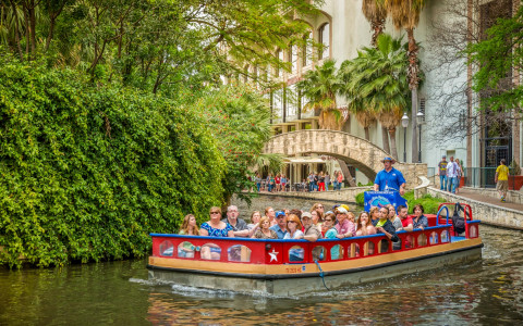 patrons on boat tour down the river walk