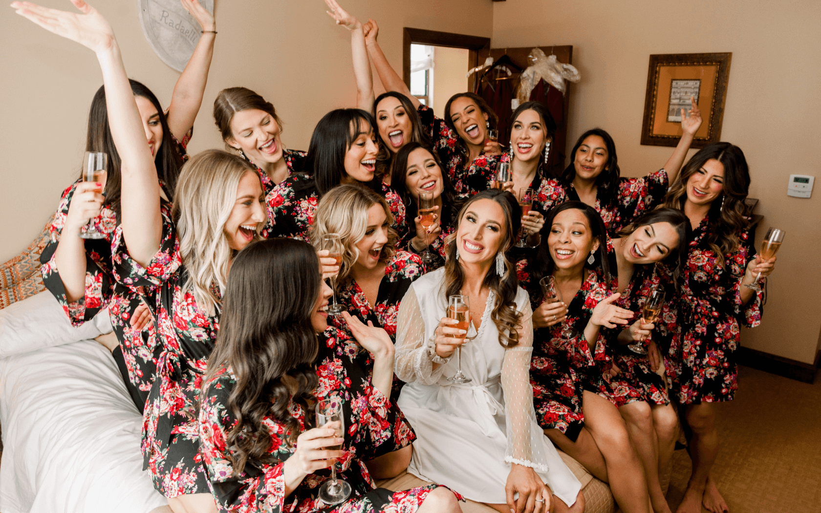 bride and bridesmaides toasting with champagne while getting ready for wedding