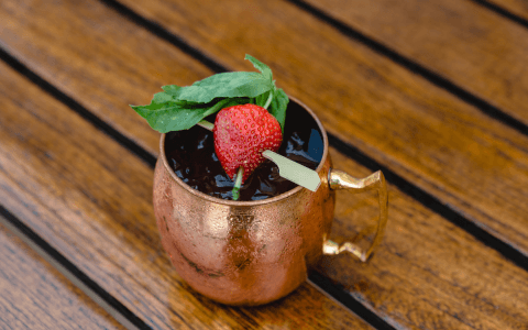 beverage in copper mug with strawberry garnish
