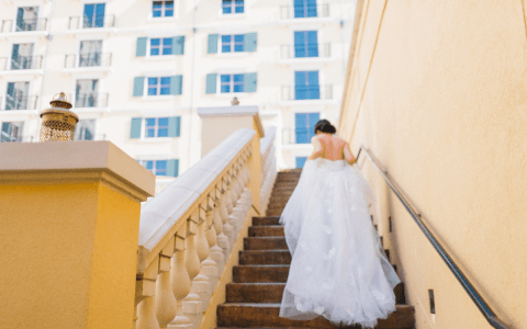 bride walking up hotel stairs in wedding gown