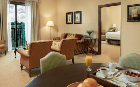 Suite living room with breakfast and peek into bedroom