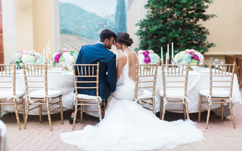 couples taking a wedding photo while seated in their outdoor venue table