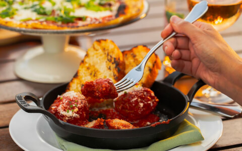 meatballs and toasted bread in a cast iron dish 