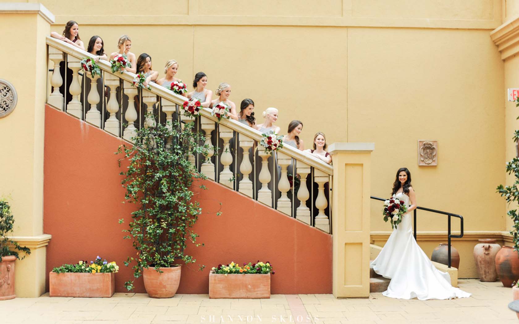 bride standing on the bottom of steps with her bridesmaids