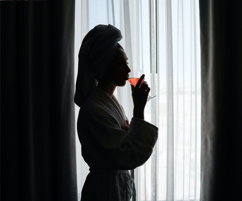 Woman drinking a cocktail by the window