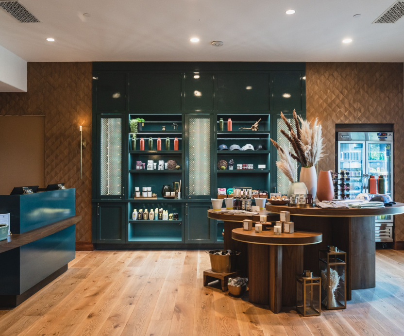 Room with a front desk and three tables and a refrigerator