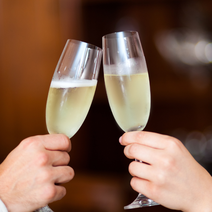 two people holding champagne glasses