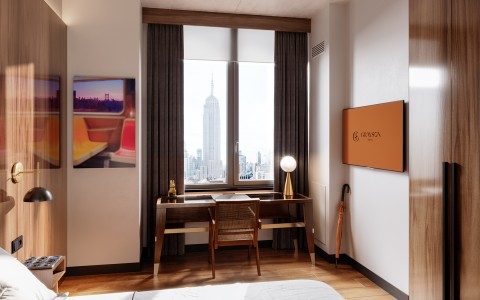 hotel room with a desk and a tv and a view to the empire state building 