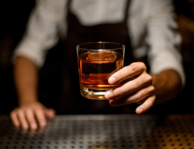 bartender serving a glass of whiskey