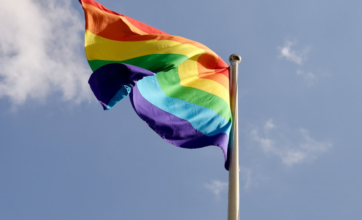 Rainbow Pride Flag against blue sky
